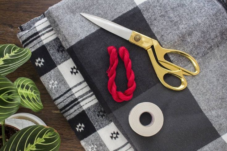 a pair of scissors sitting on top of a black and white checkered table cloth