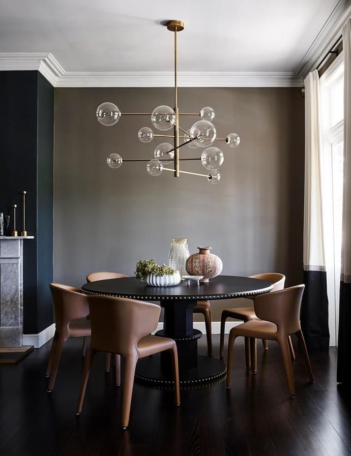 a dining room table with four chairs and a chandelier hanging from the ceiling