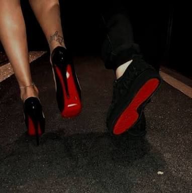 a woman's feet with red and black shoes