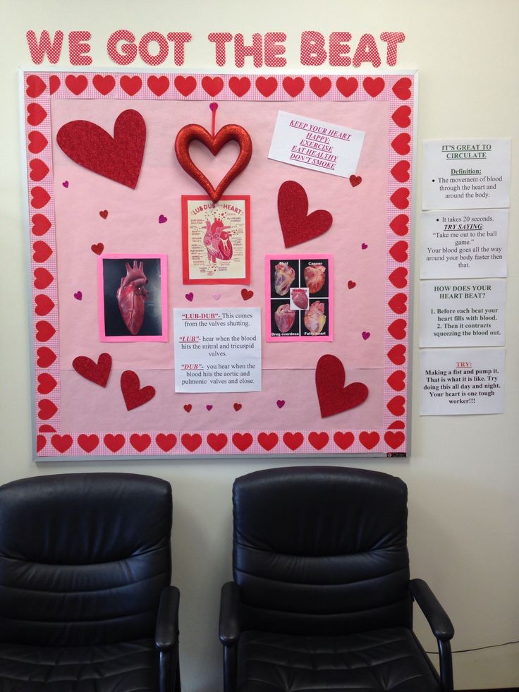 two black chairs sitting in front of a bulletin board with pictures and hearts on it