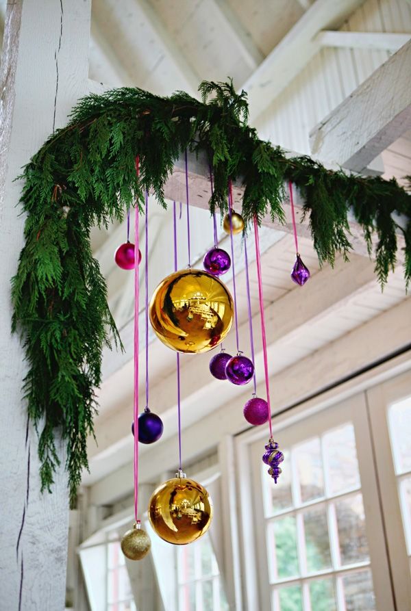 christmas decorations hanging from the ceiling with pine branches and ornaments on it's side