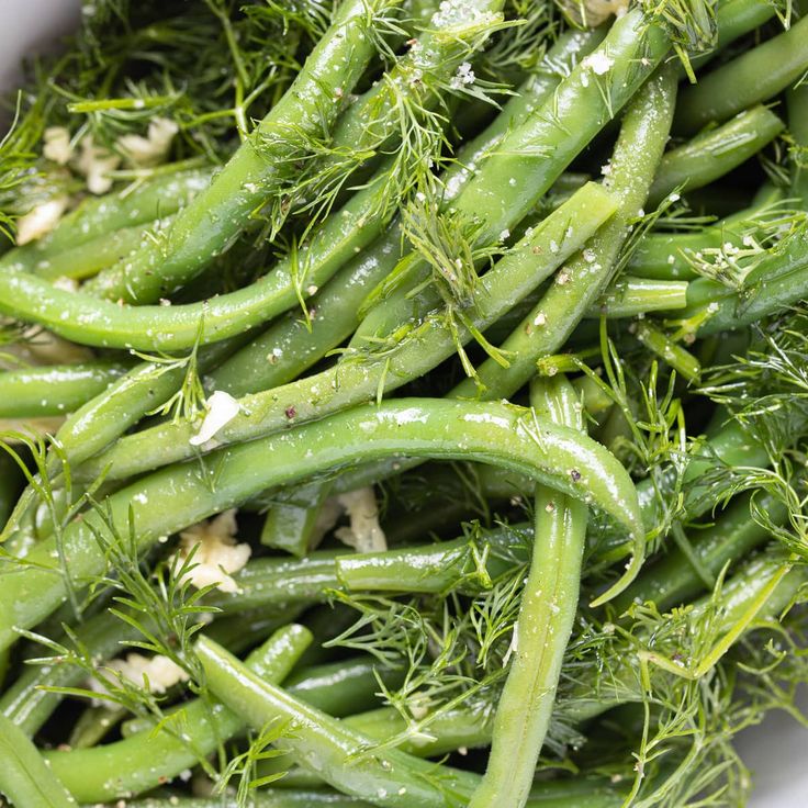 green beans and dill sprouts in a white bowl