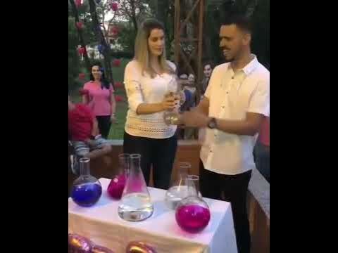 two people standing next to each other at a table filled with glassware and bottles