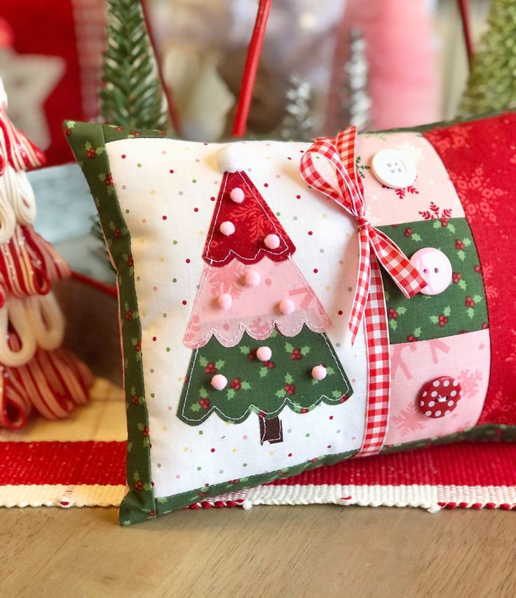 two decorative christmas pillows on a table