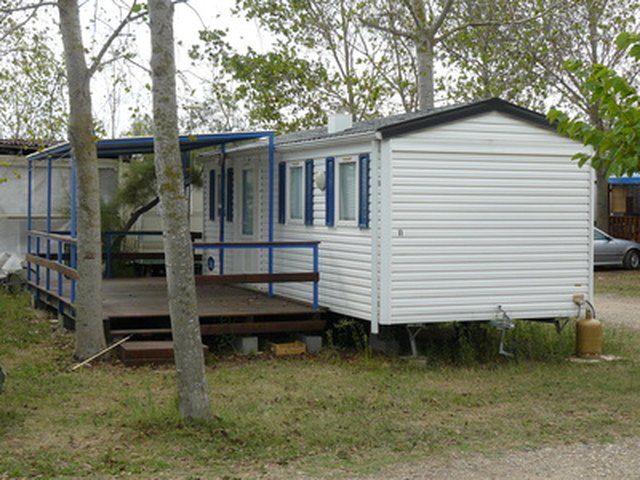 a mobile home sits in the middle of a wooded area