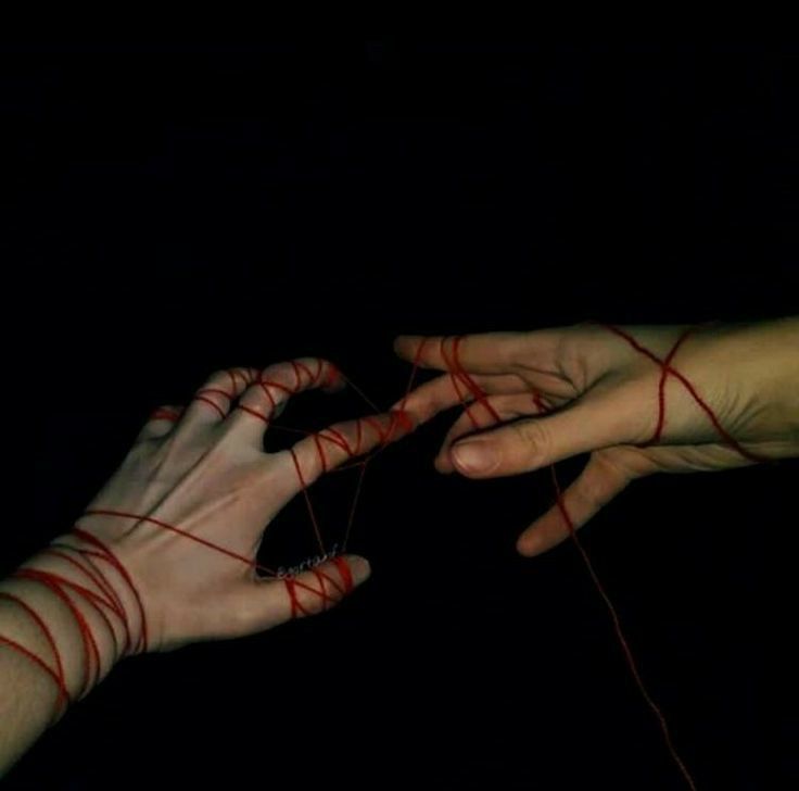 two hands with red string attached to each other