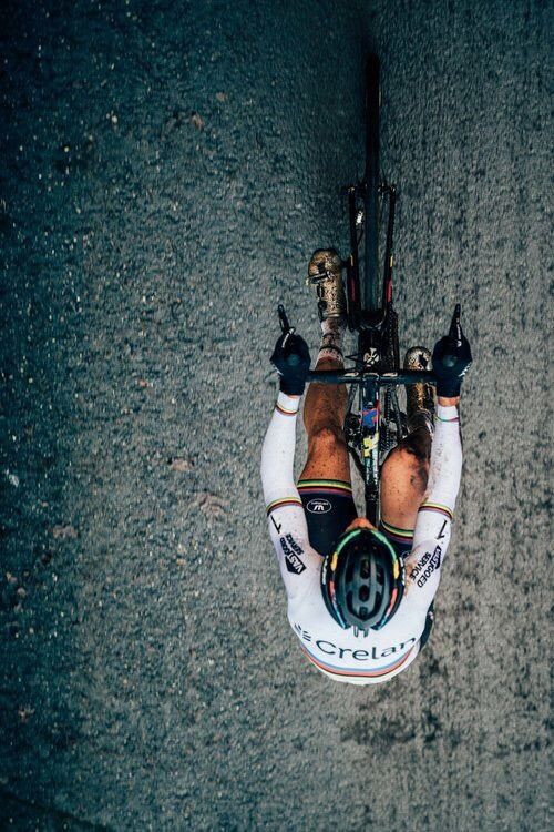 a man riding on the back of a bike down a street