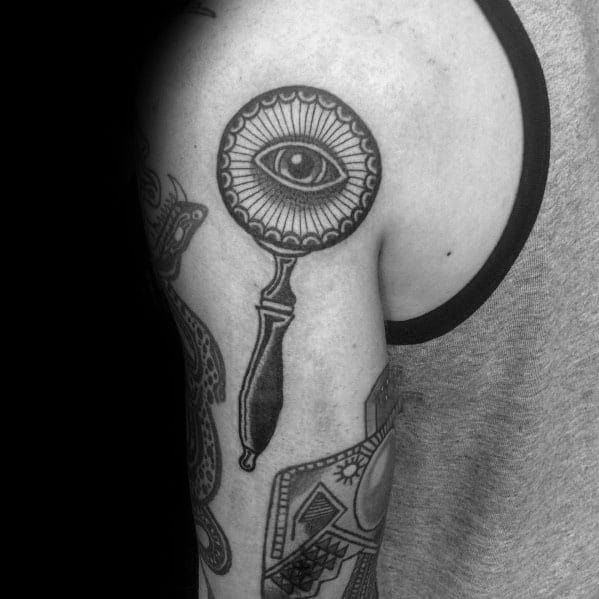 a black and white photo of a man's arm with an all seeing eye on it