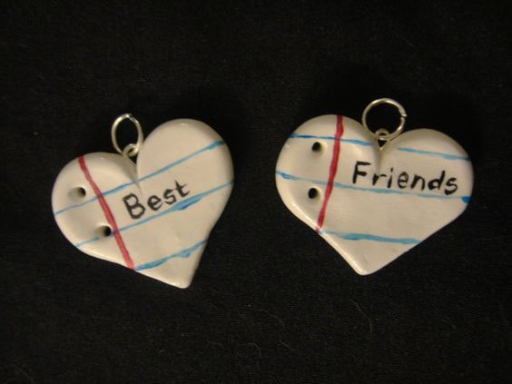 two ceramic heart shaped key chains with the words best and friends written on each one