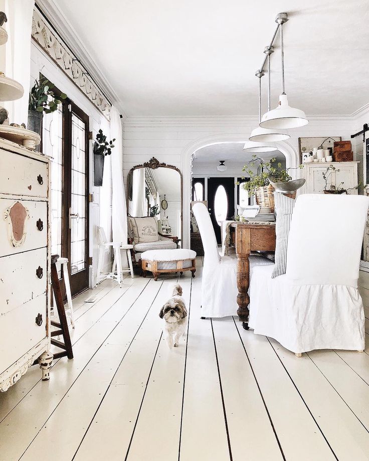 a living room with white furniture and wooden floors