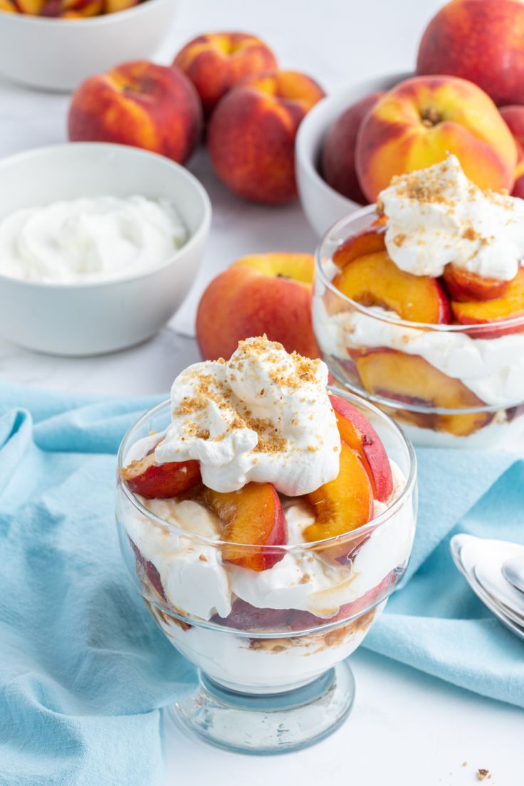 two dessert dishes with peaches and whipped cream