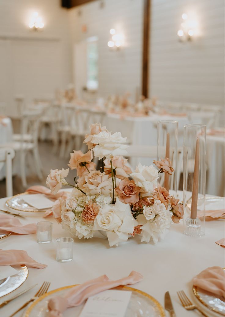 the table is set with pink and white flowers