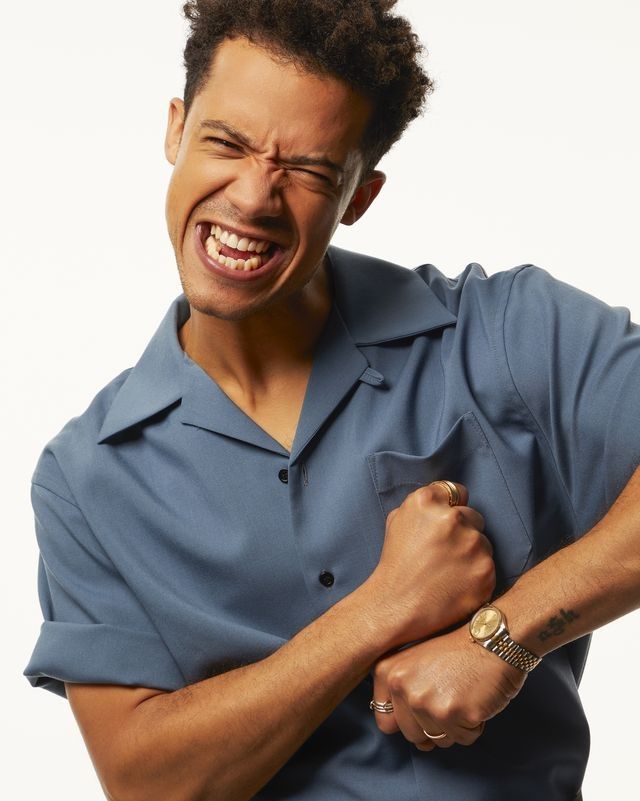 a man with an angry look on his face and arm, wearing a blue shirt