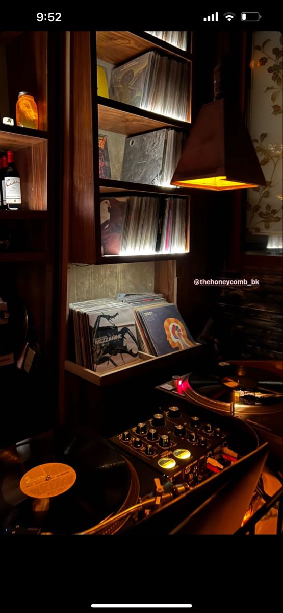 an old record player is sitting in front of a shelf full of records and cds