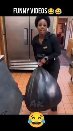 a woman holding a large black bag in her hands and smiling at the camera with an emoticive message on it