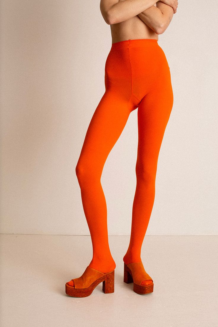 Orange opaque footed 80D tights. Reinforced crotch. Fabric is 84% Nylon, and 16% Spandex. Ella is 6' tall, 36" bust, 27.5" waist, 38" hip, and is wearing a size L/XL. See size chart below. Measurements are taken flat. These tights are extremely stretchy. For more opacity, choose the L/XL. High Waist Tight Nylon Tights, High Waist Stretch Nylon Tights, High Waist Stretch Elastane Hosiery, High-cut Compression Tights, High Waist Stretch Elastane Legwear, High Stretch High Waist Solid Hosiery, High Stretch High Waist Hosiery, High Waist High Stretch Solid Hosiery, Solid Compression Nylon Tights