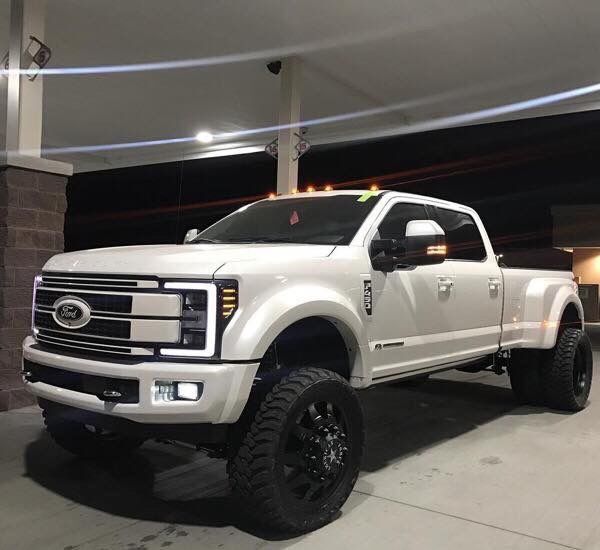 a large white truck parked in a garage next to a building with lights on it's roof