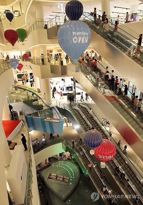 an overhead view of people shopping in a mall with hot air balloons hanging from the ceiling