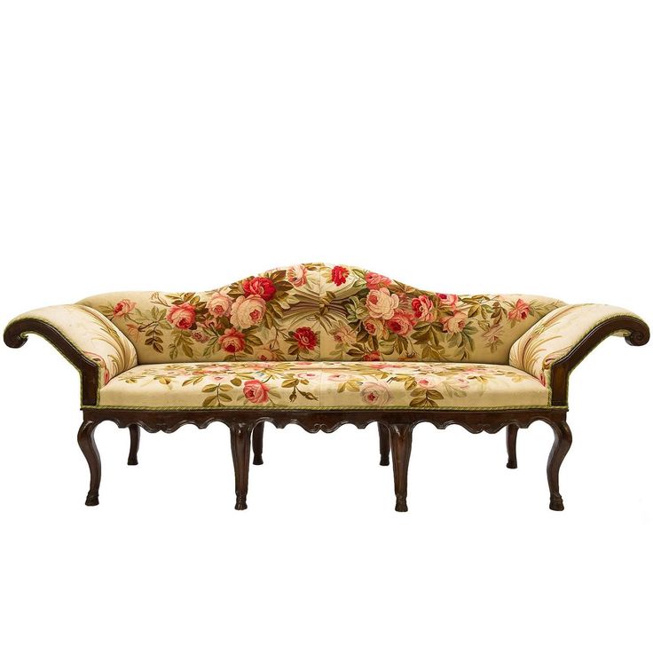 an old fashioned couch with floral fabric on it's back and arms, sitting in front of a white background