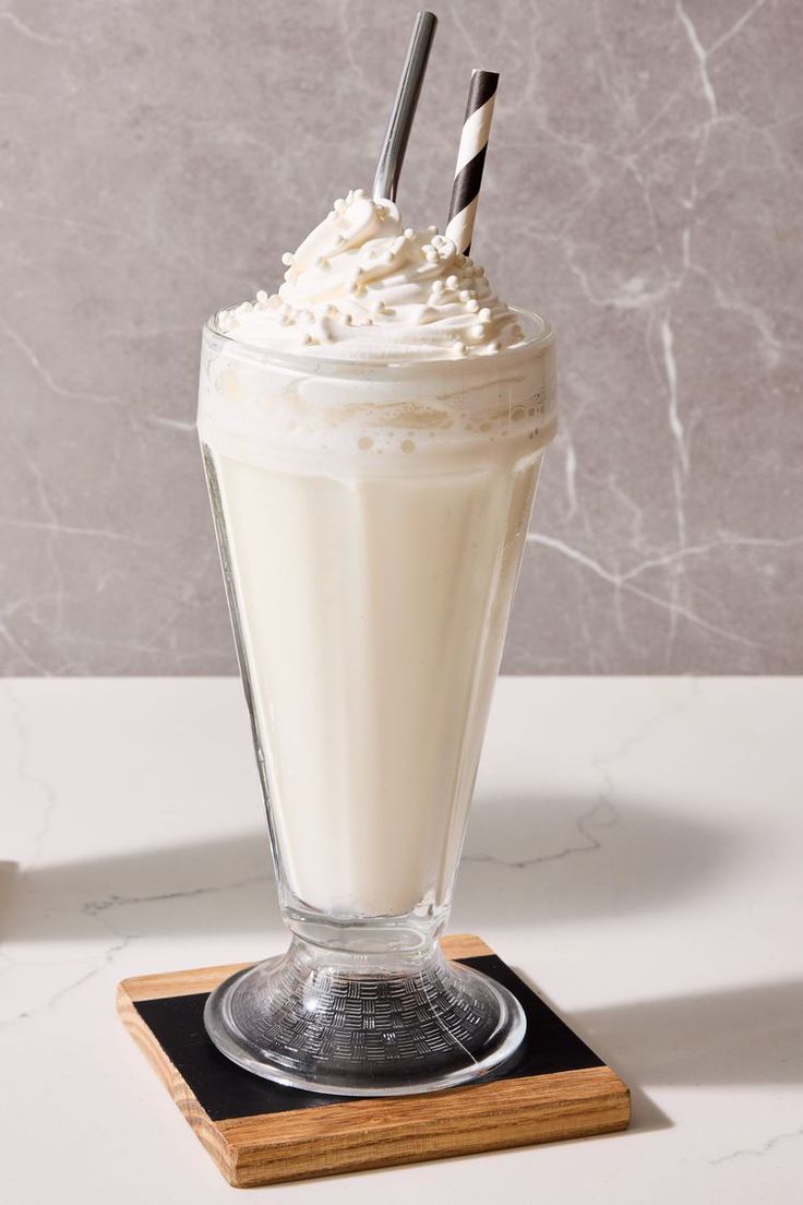 a drink with whipped cream and two drinking straws