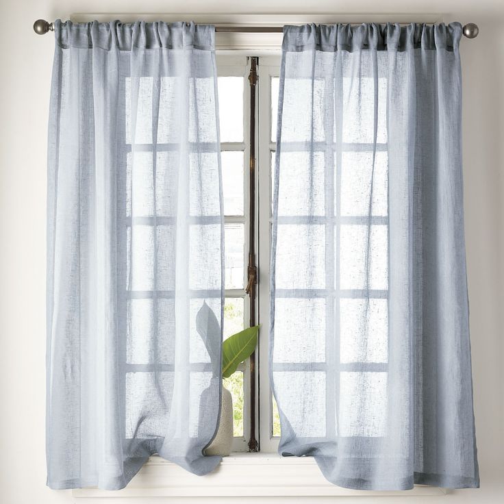 a window with blue curtains and a green plant