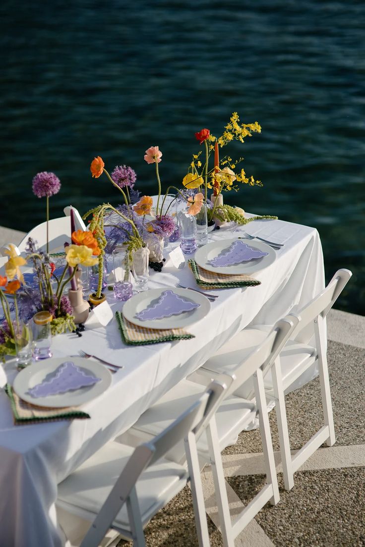 the table is set with flowers and plates