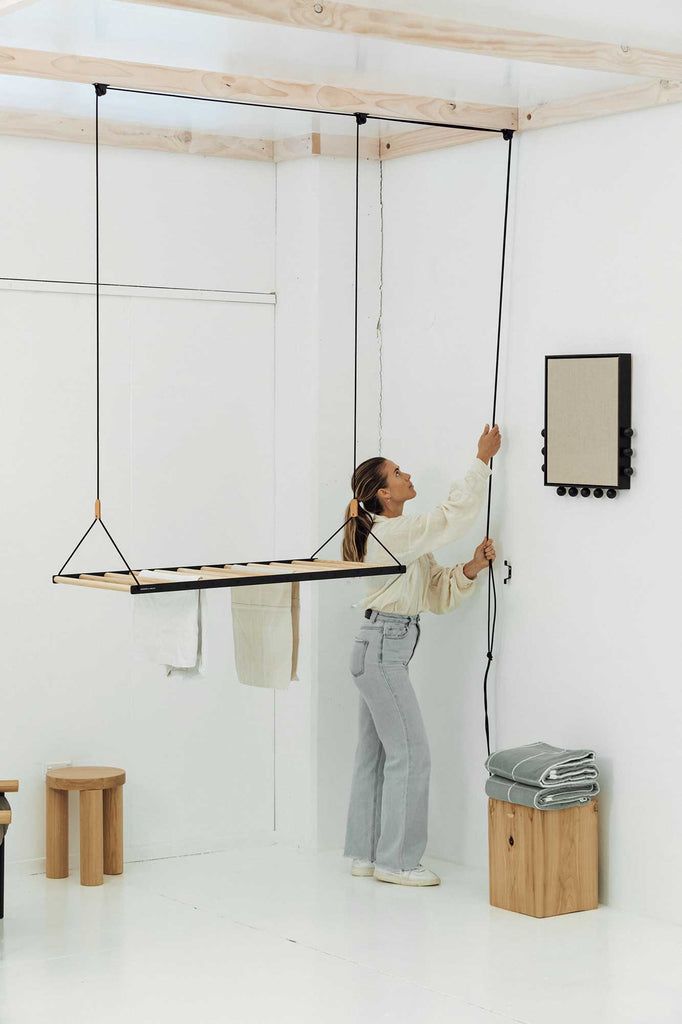 a woman standing on a swing in the middle of a room