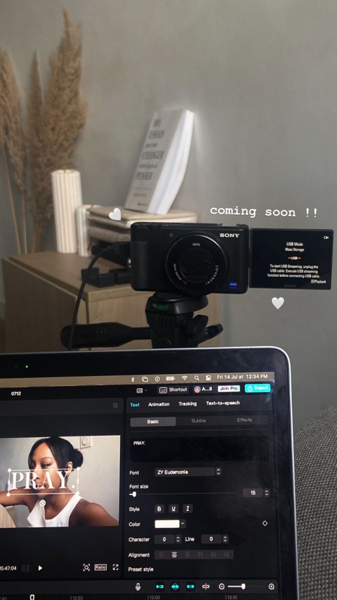 a laptop computer sitting on top of a desk next to a video camera and remote control