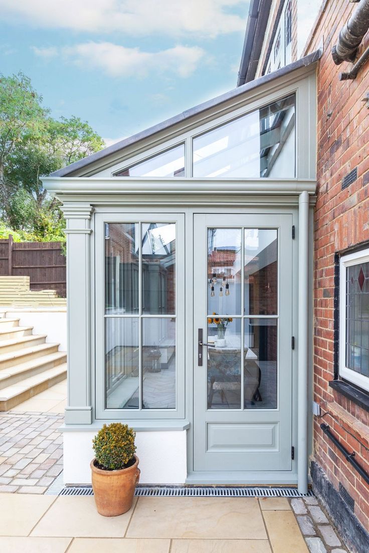 an orange brick building with glass doors on the front and side walk up to it