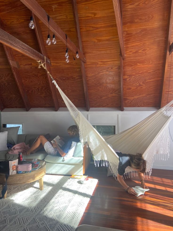 two people sitting in a hammock reading books