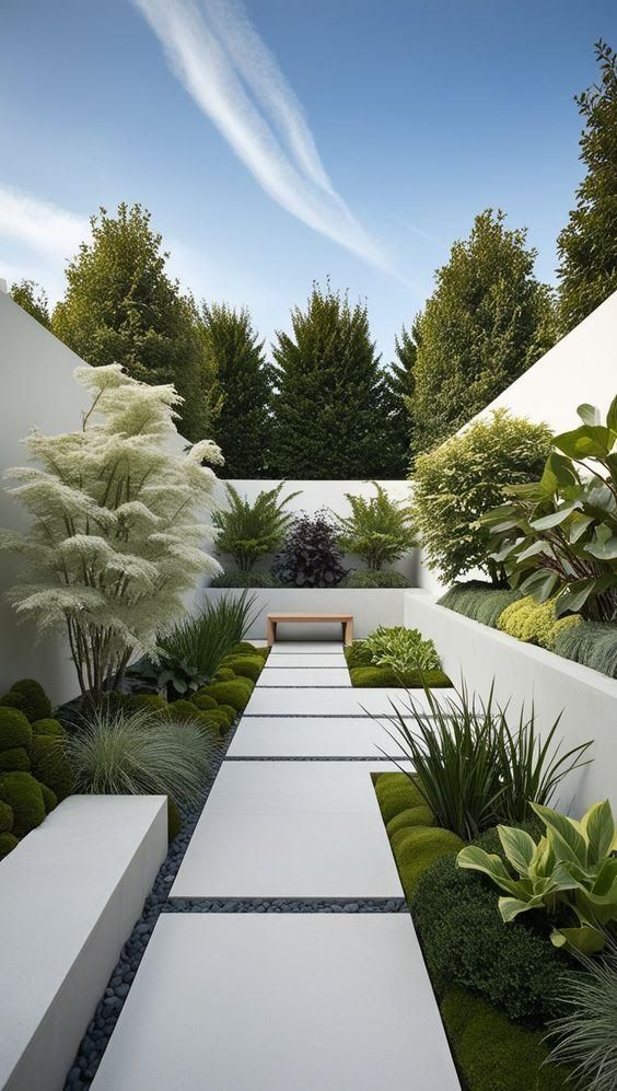 an outdoor garden with white benches and green plants