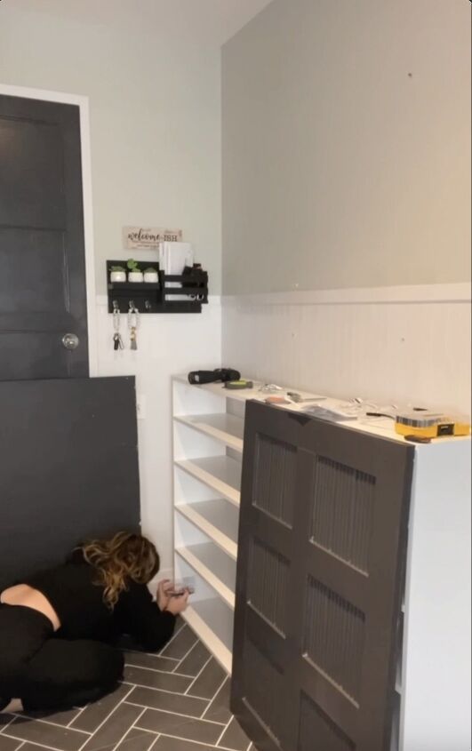 a woman laying on the floor in front of a black and white bookcase next to a gray door