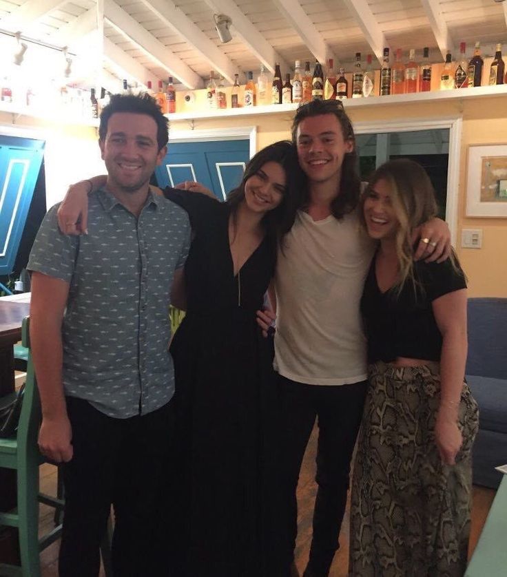 a group of people standing next to each other in front of a table with drinks on it