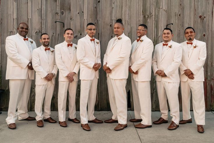 a group of men in white suits standing next to each other