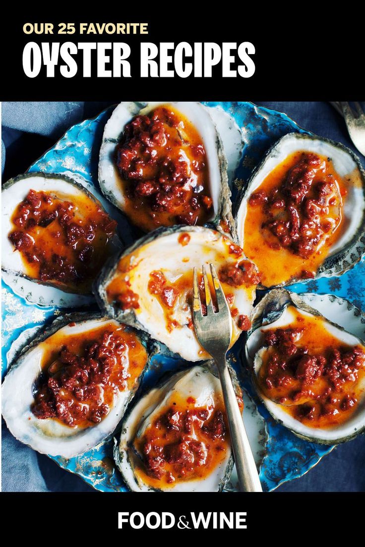 a blue plate topped with oysters covered in sauce