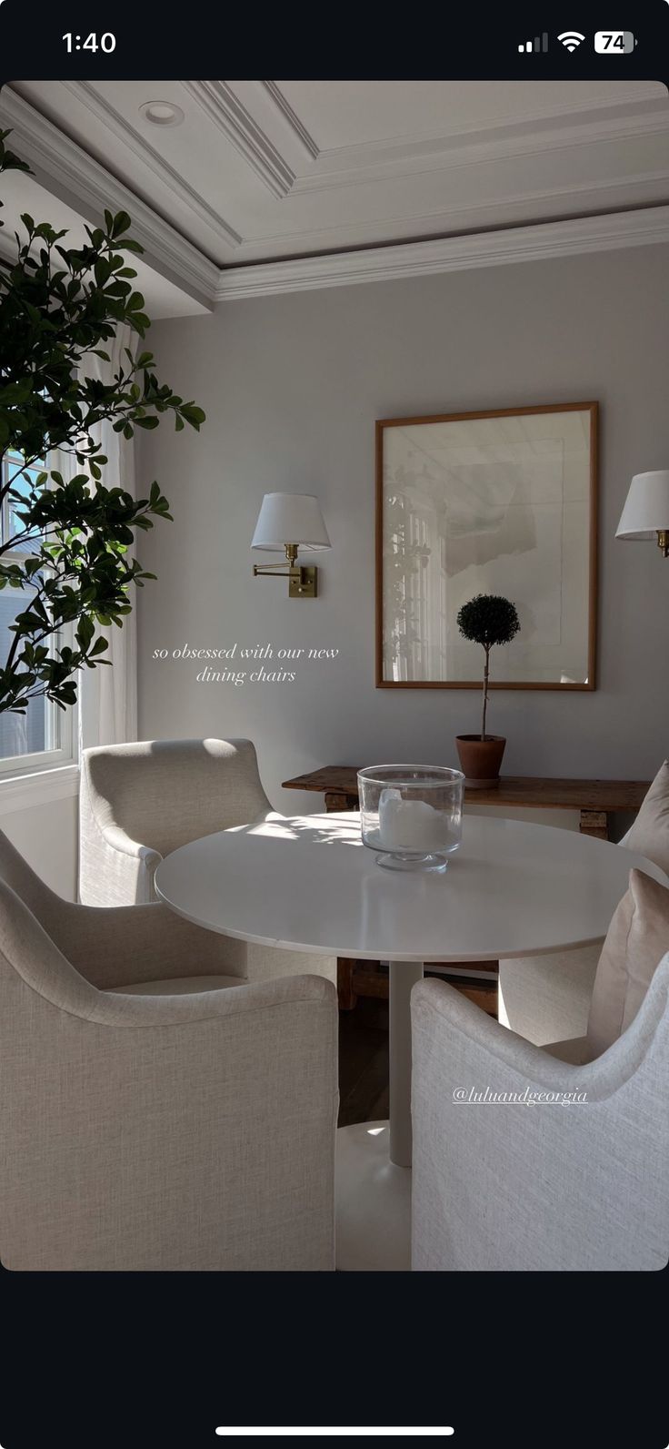 a dining room with white chairs and a round table