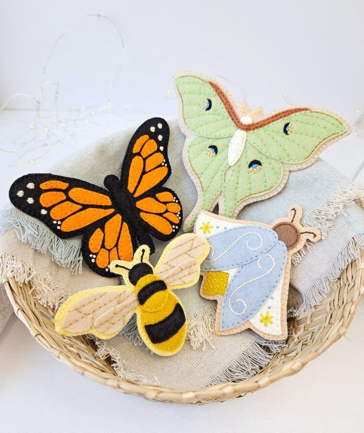 three felt butterfly and bee appliques in a basket