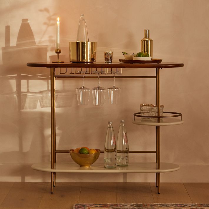 a bar cart with wine glasses and bottles on it