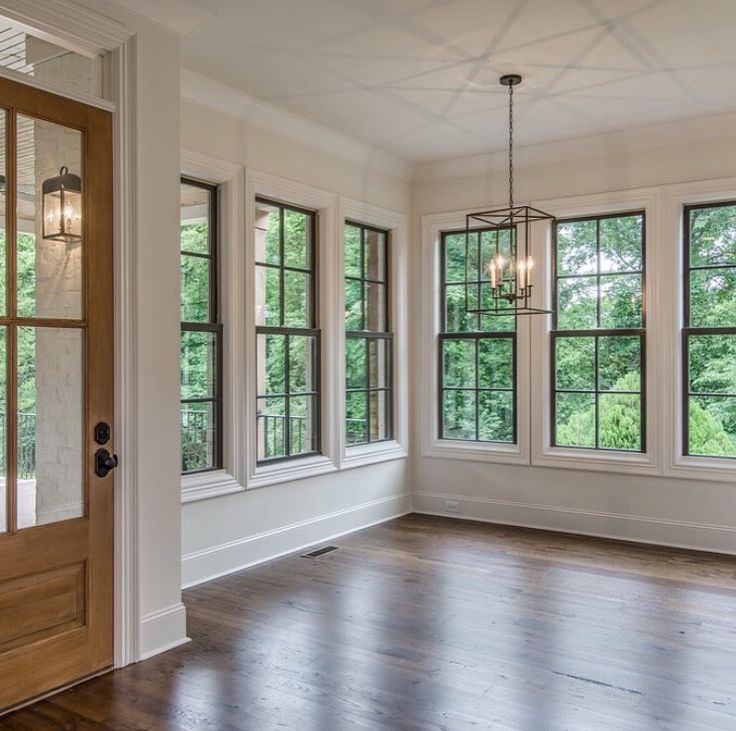 an empty room with wood floors and windows