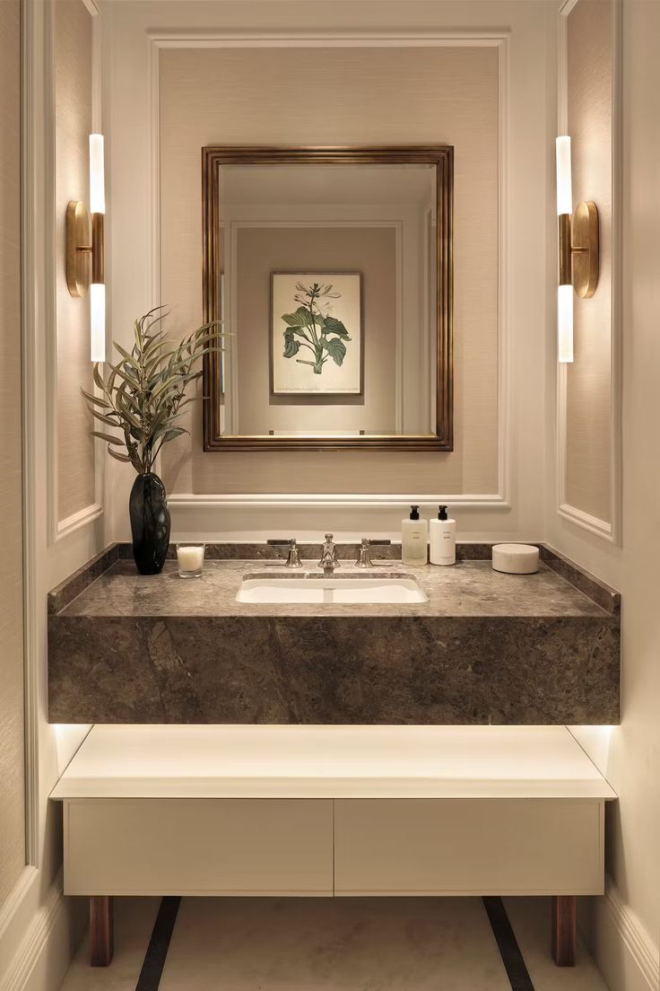 a bathroom sink with a mirror above it and a vase on the counter next to it