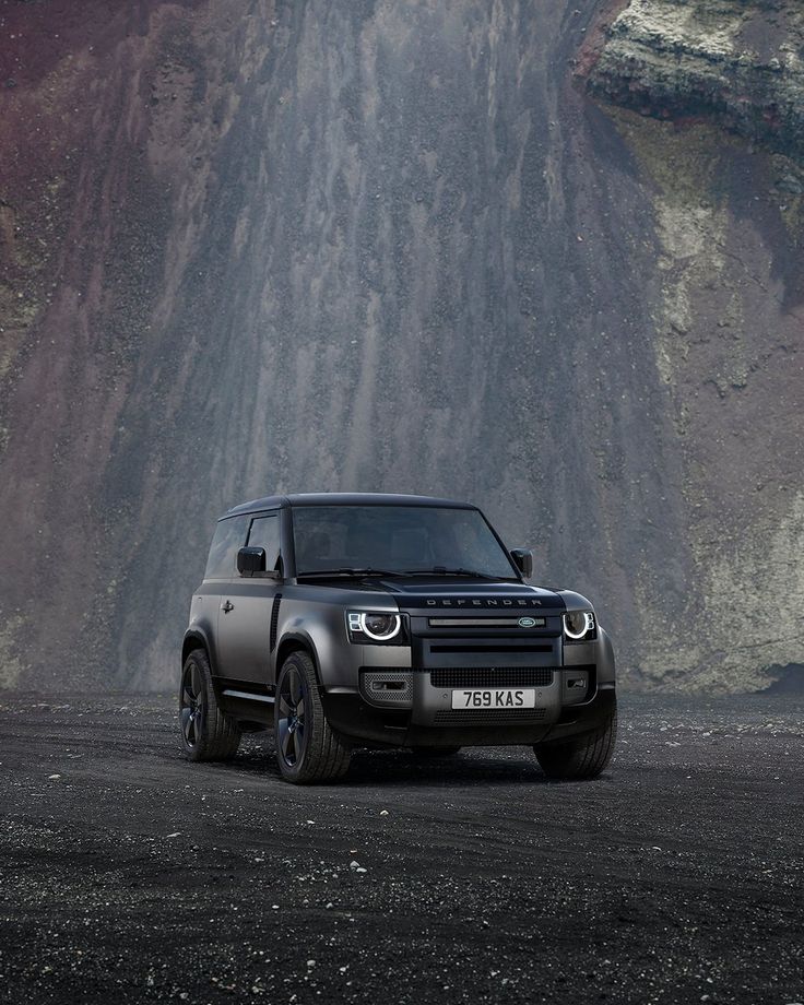 an suv is parked in front of a mountain