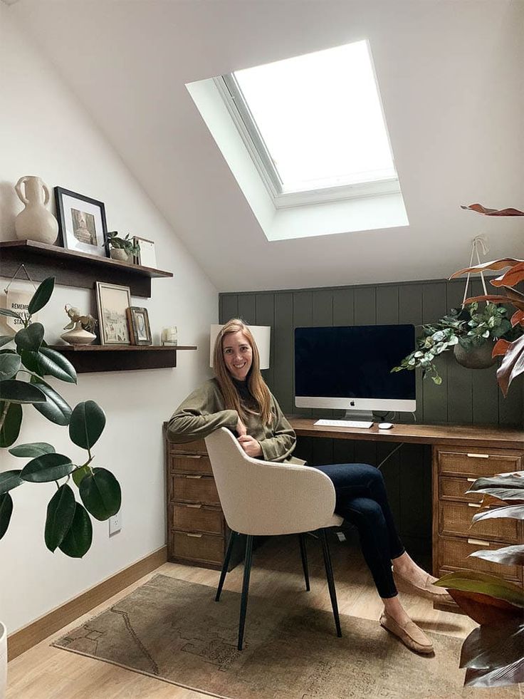 a woman sitting at a desk in front of a tv