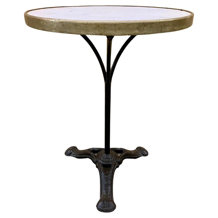 an iron and marble table with a cross on the base, isolated against a white background