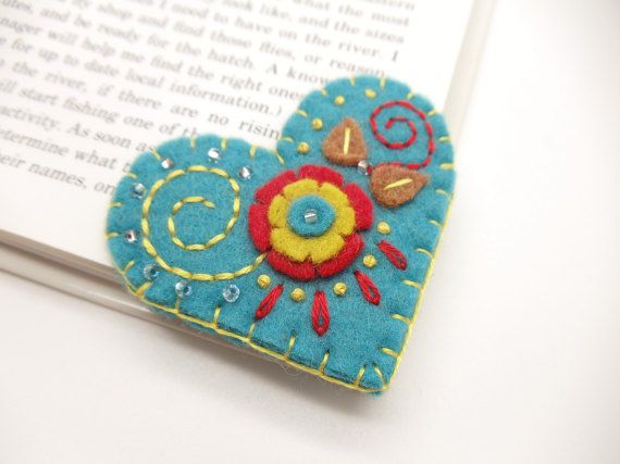 a heart shaped brooch sitting on top of an open book