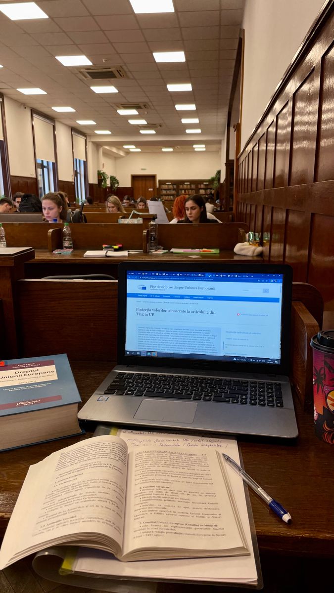 an open book sitting on top of a desk next to a laptop computer