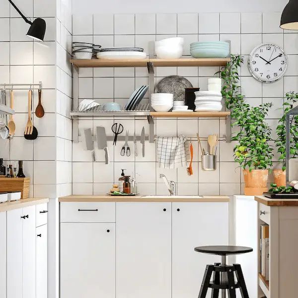 a kitchen filled with lots of appliances and counter top space next to a wall mounted clock