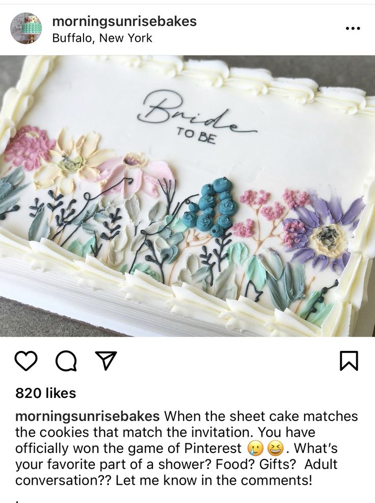 the cake is decorated with flowers and leaves on it's white frosting sheet