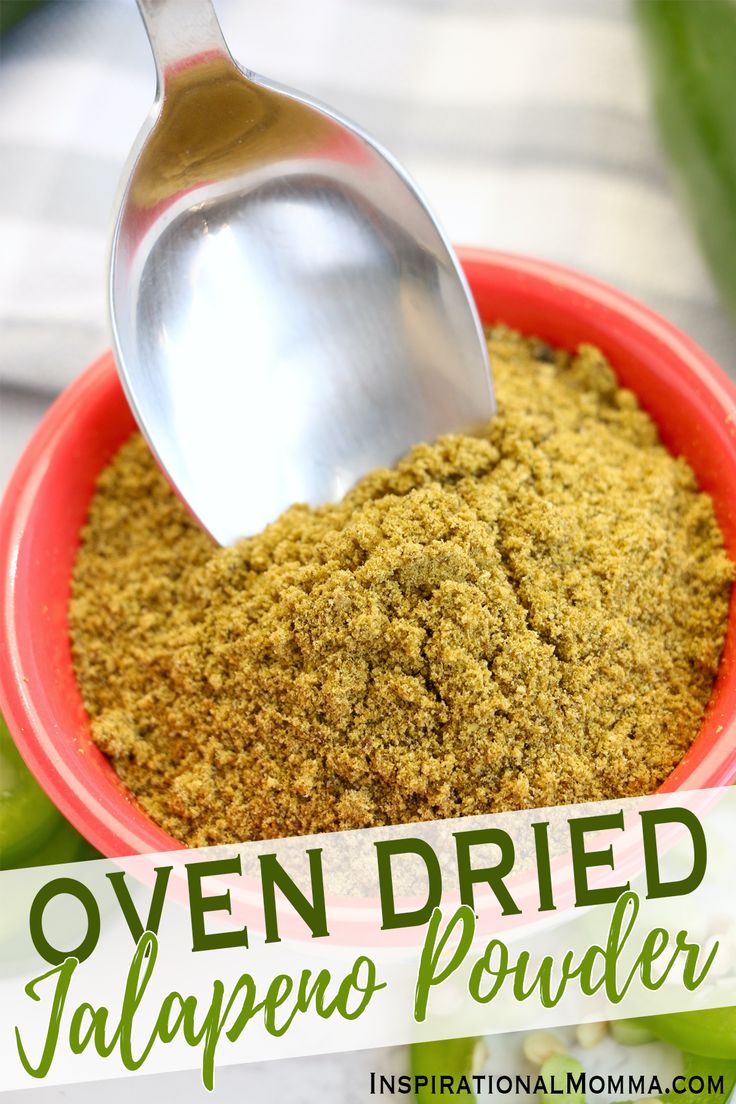 a spoon scooping out some green powder into a red bowl with the words oven dried jalapeno powder in it