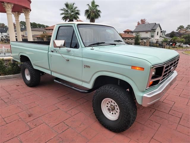 a light blue pick up truck parked in front of a house on a brick driveway