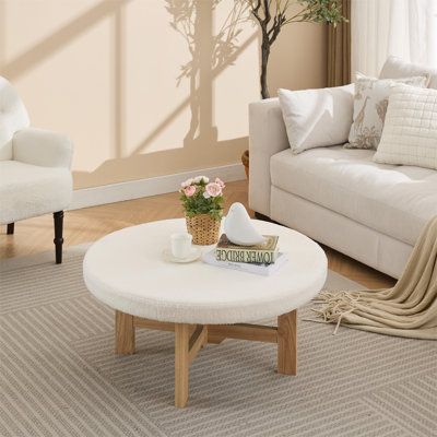 a living room with two white couches and a coffee table in front of a window